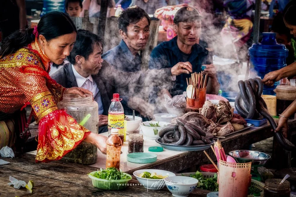 Local hill-tribe people enjoying steamy breakfast at market in Dong Van, Ha Giang, North Vietnam.