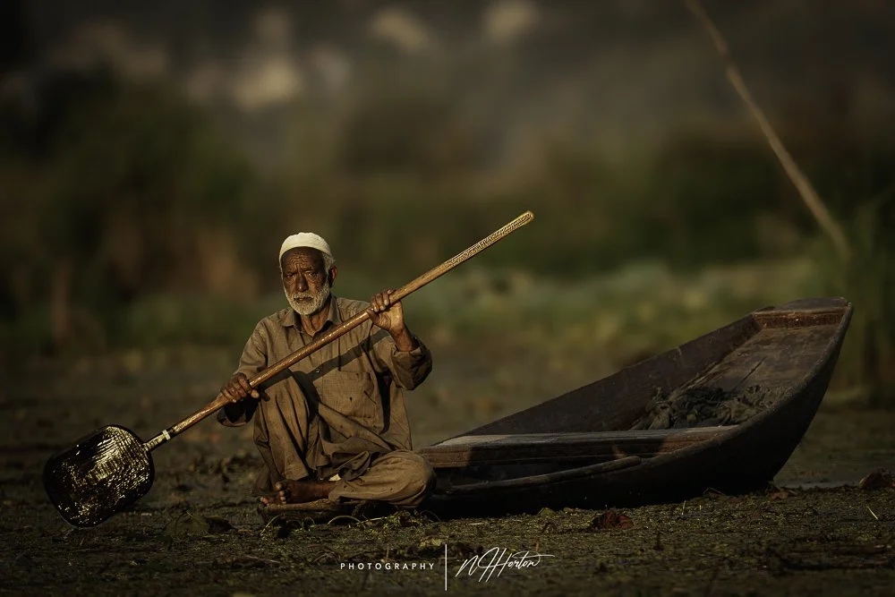 Man on boat Dal Lake Srinagar, Kashmir, India.