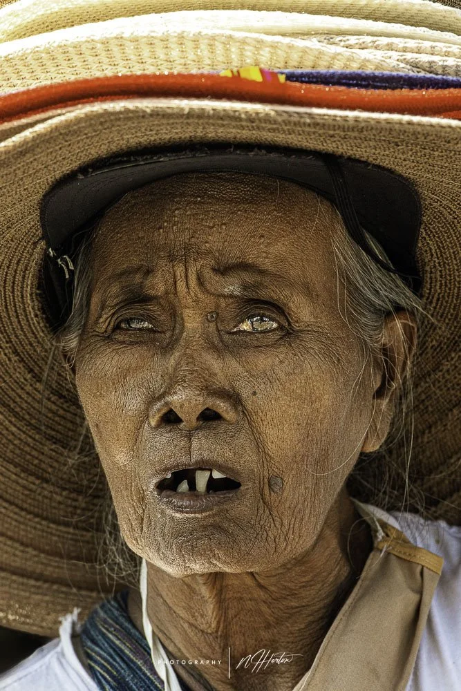 Portrait of lady wearing many hats in Indonesia