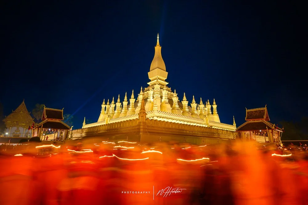 Monks circumnavigate temple at That Luang festival, Vientiane, Laos