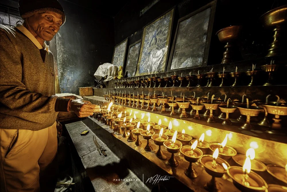 Man-lighting-candles-in-monastery-Arunachal-Pradesh-India