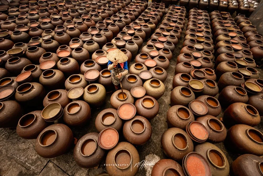 Female-worker-stirs-Soya-sauce-in-yard-North Vietnam.