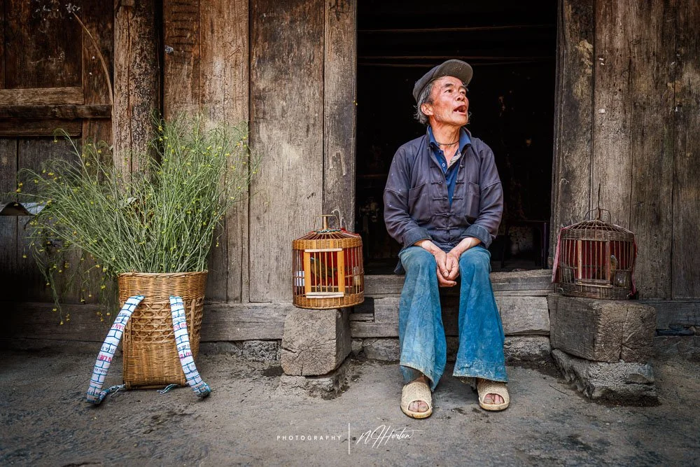 Old character in door way in ancient village, Ha Giang Loop, Vietnam.