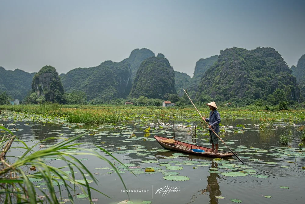 Boat-on-river-among-sugar-loaf-monutains, North Vietnam.