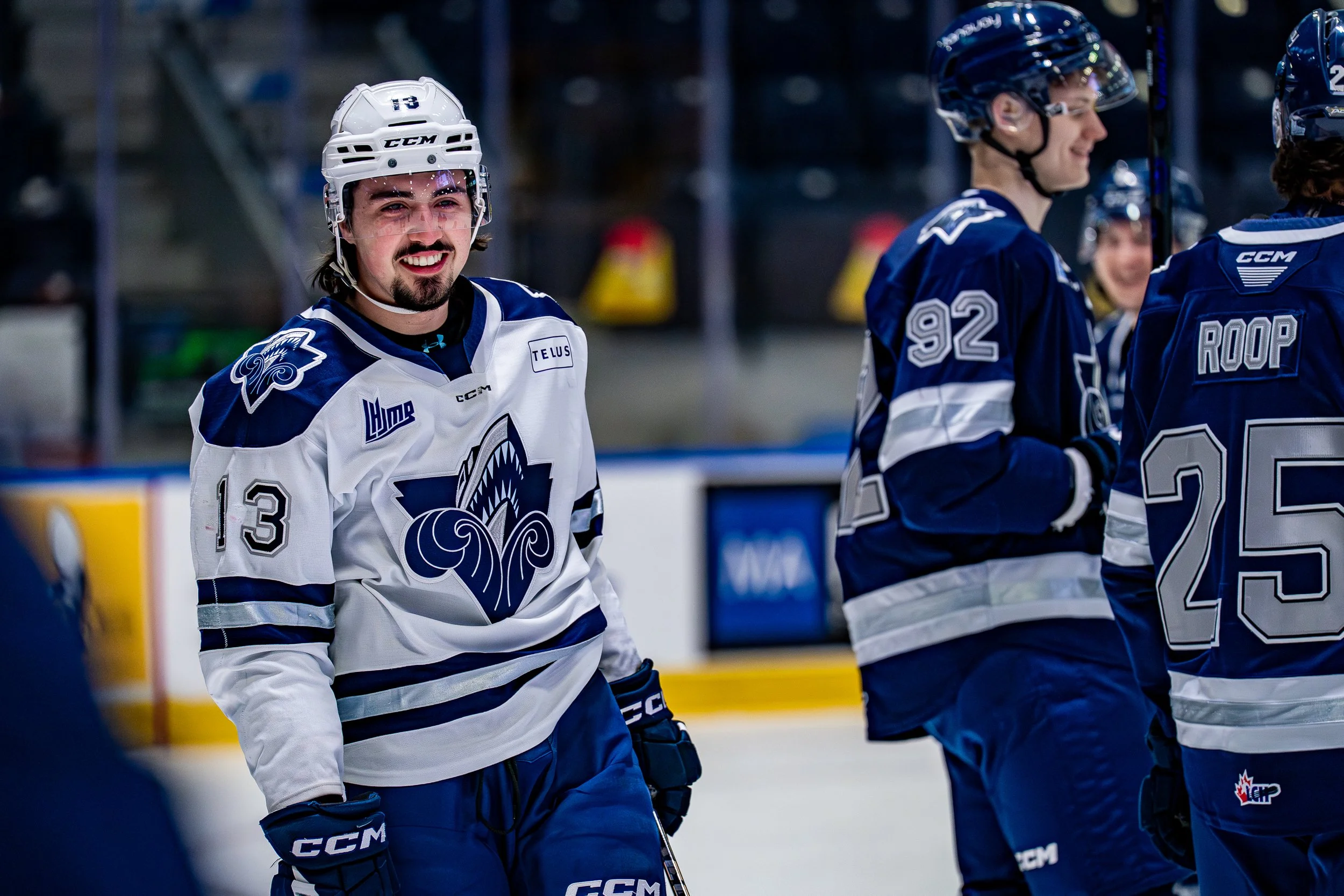 Équipes de hockey sur glace en uniforme bleu et blanc sur la glace.