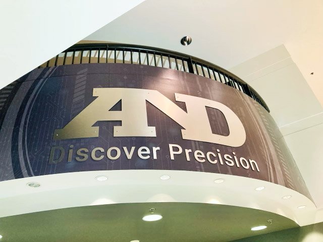 Balcony graphics final installation photos, featuring the curved metal logo.