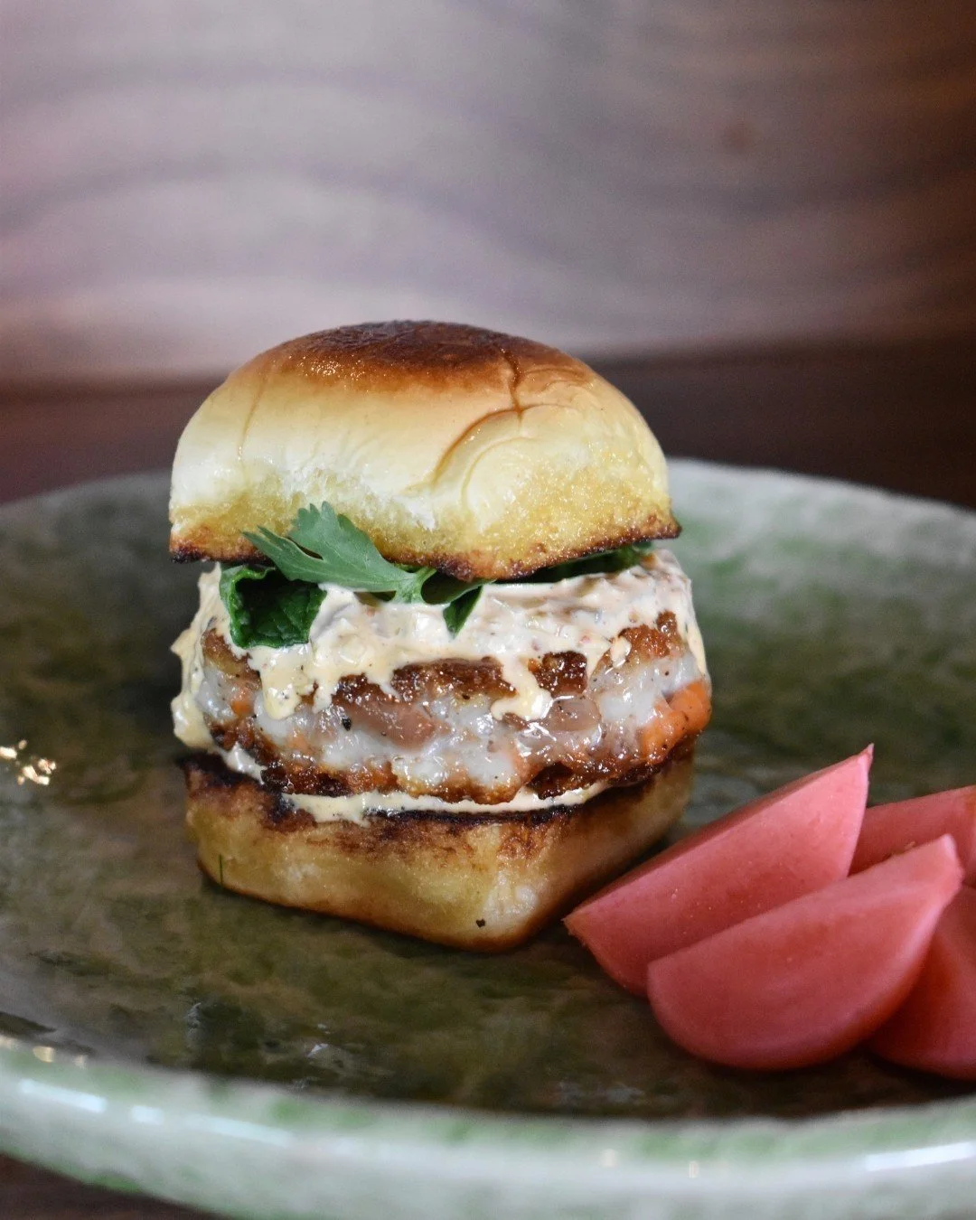 Our Fish Sausage Slide on a Martin&rsquo;s Potato Roll drizzled in yummers sauce is one small bite with seriously big flavor. 😍