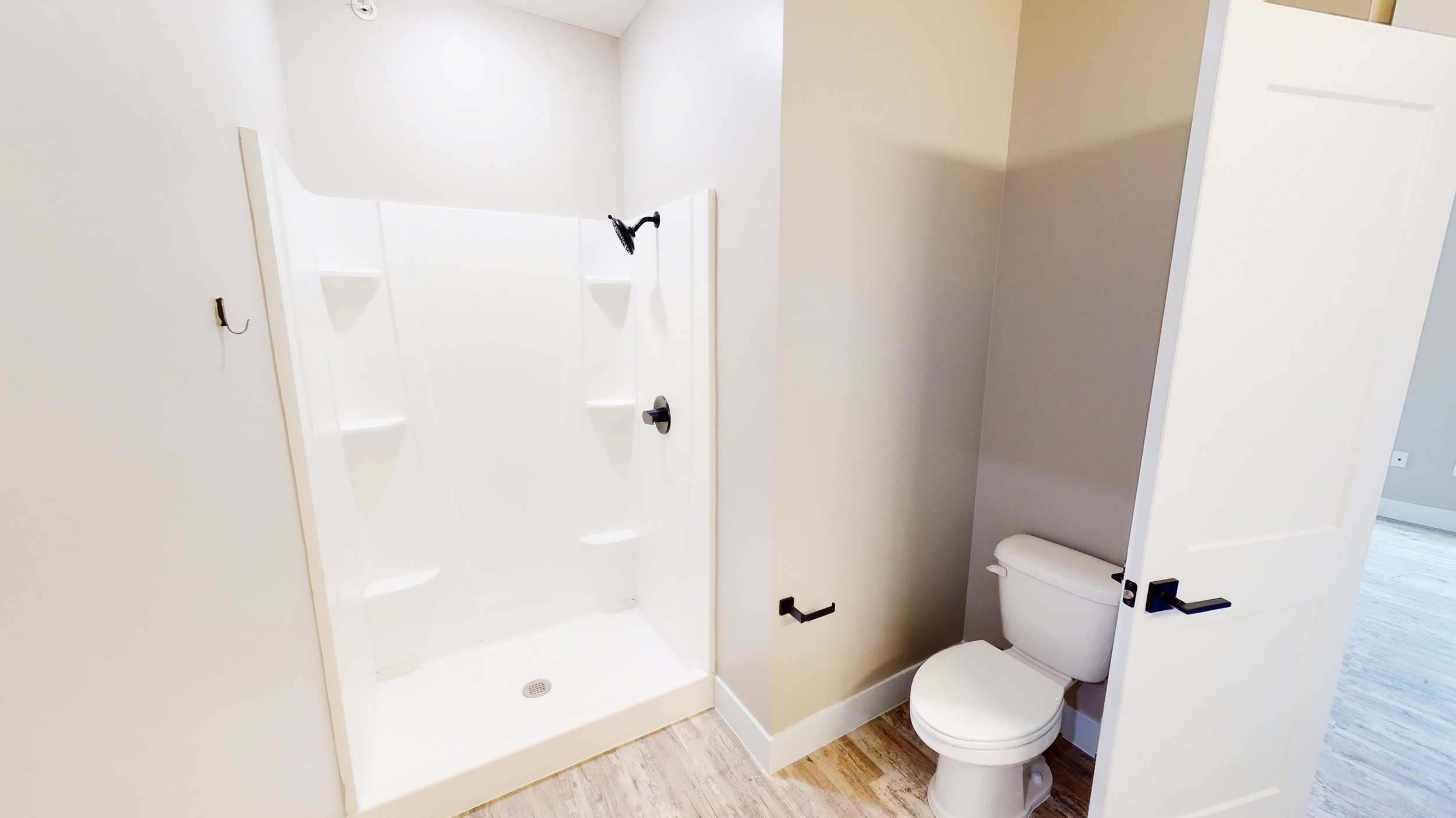 Bathroom with a white shower stall and toilet.