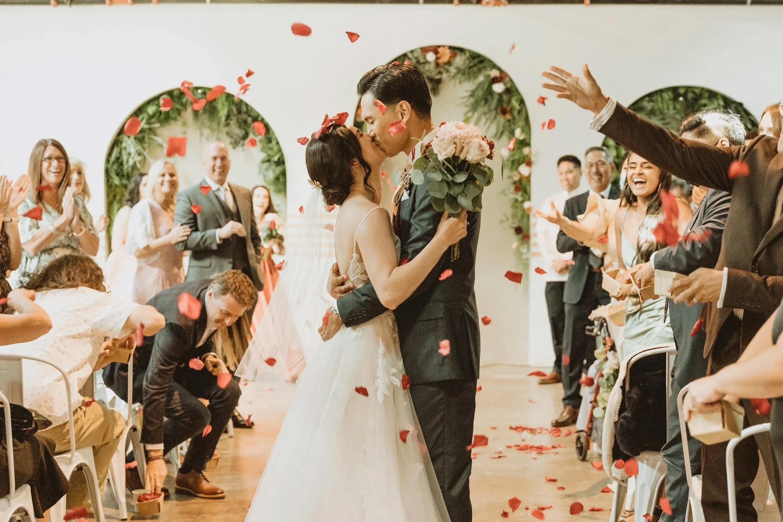 A happy couple sharing their first kiss at their wedding at the Vistonian Wedding Venue in Vista CA.