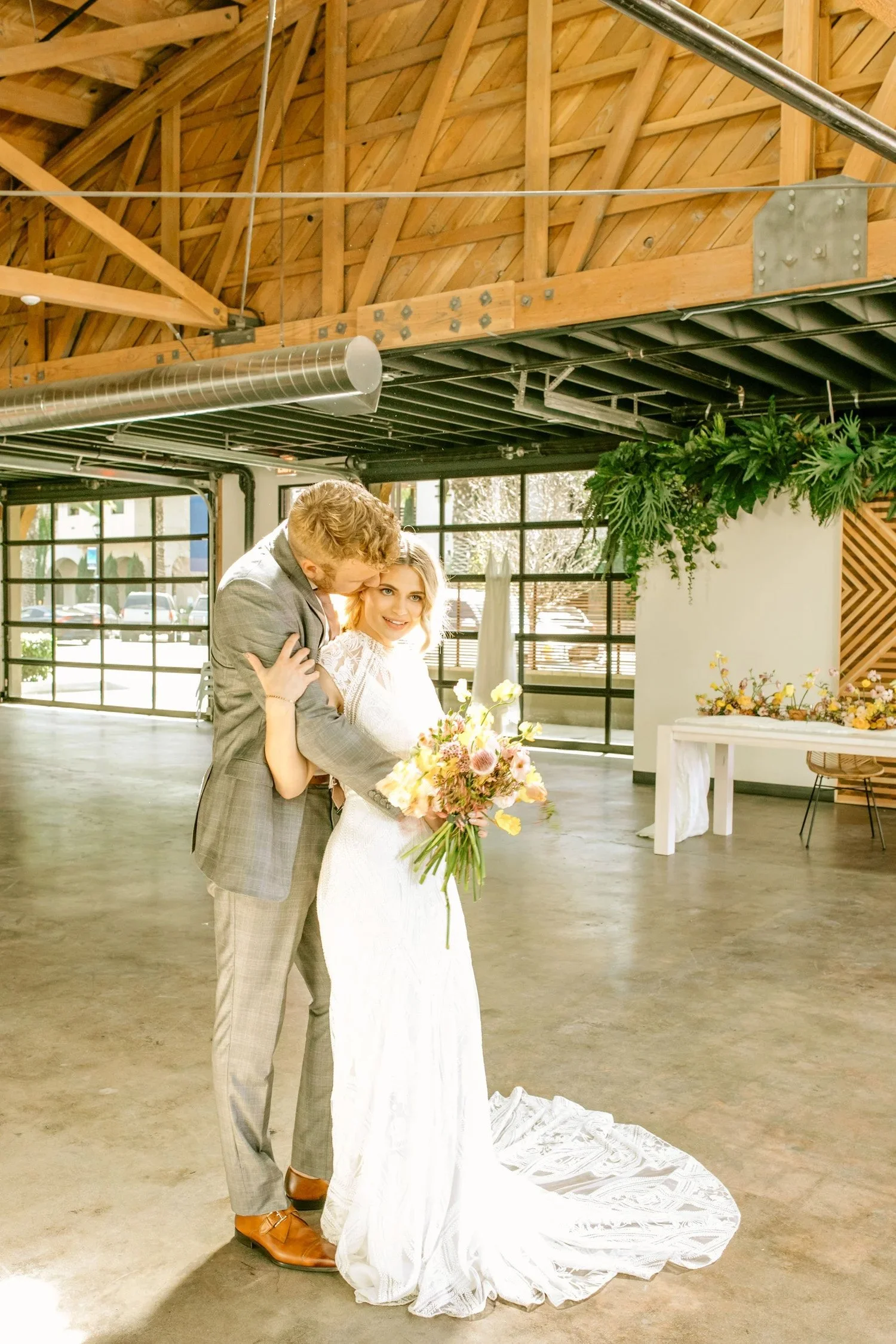 A happy couple posing for a photo in the industrial and modern wedding venue in San Diego CA called The Vistonian