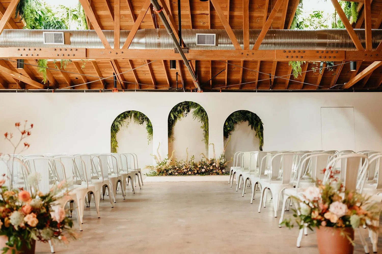 A view of the ceremony arches and wedding seating at The Vistonian wedding venue in San Diego CA