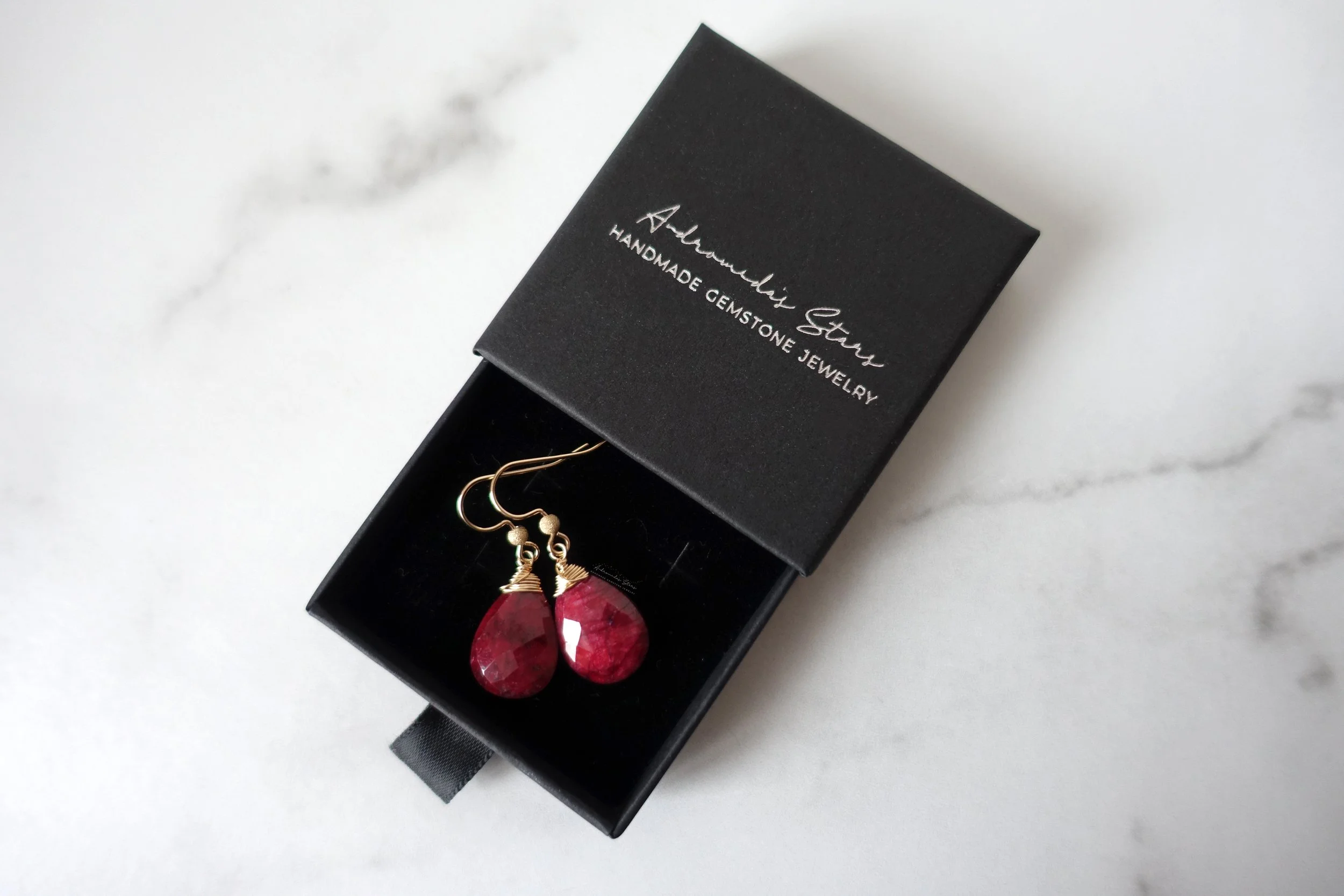 red ruby earrings in black box.jpg
