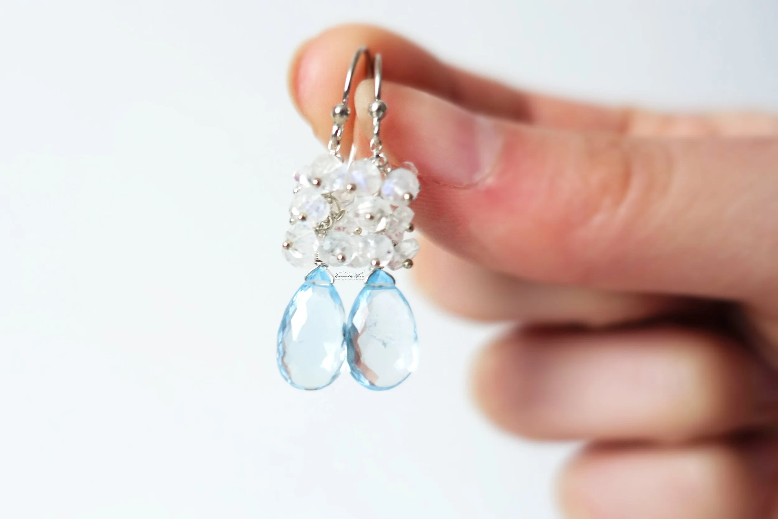 blue topaz moonstone earrings holding.jpg