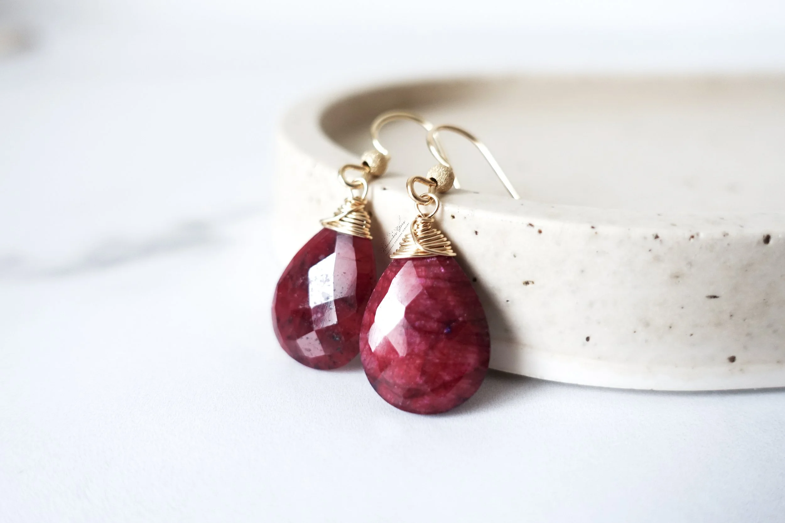 red ruby earrings against tray.jpg