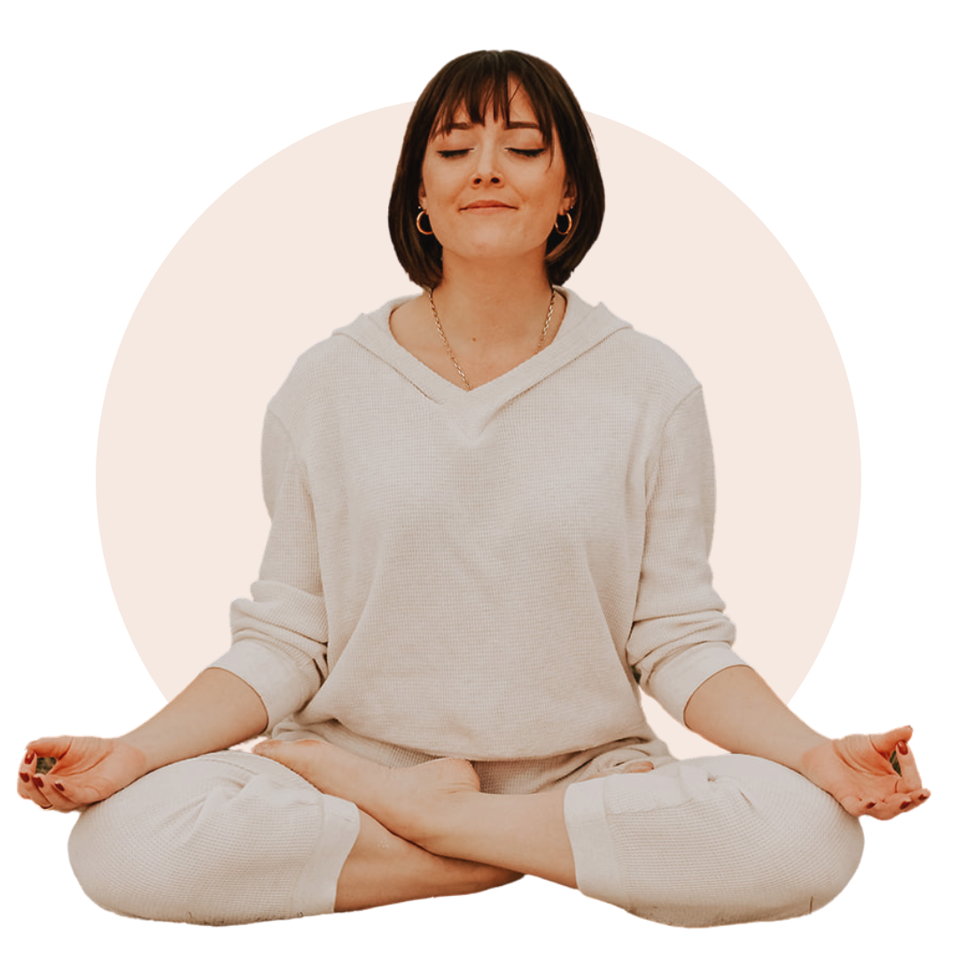Young woman with brown hair wearing a ivory sweater set in a meditative posture with her eyes closed and a smile