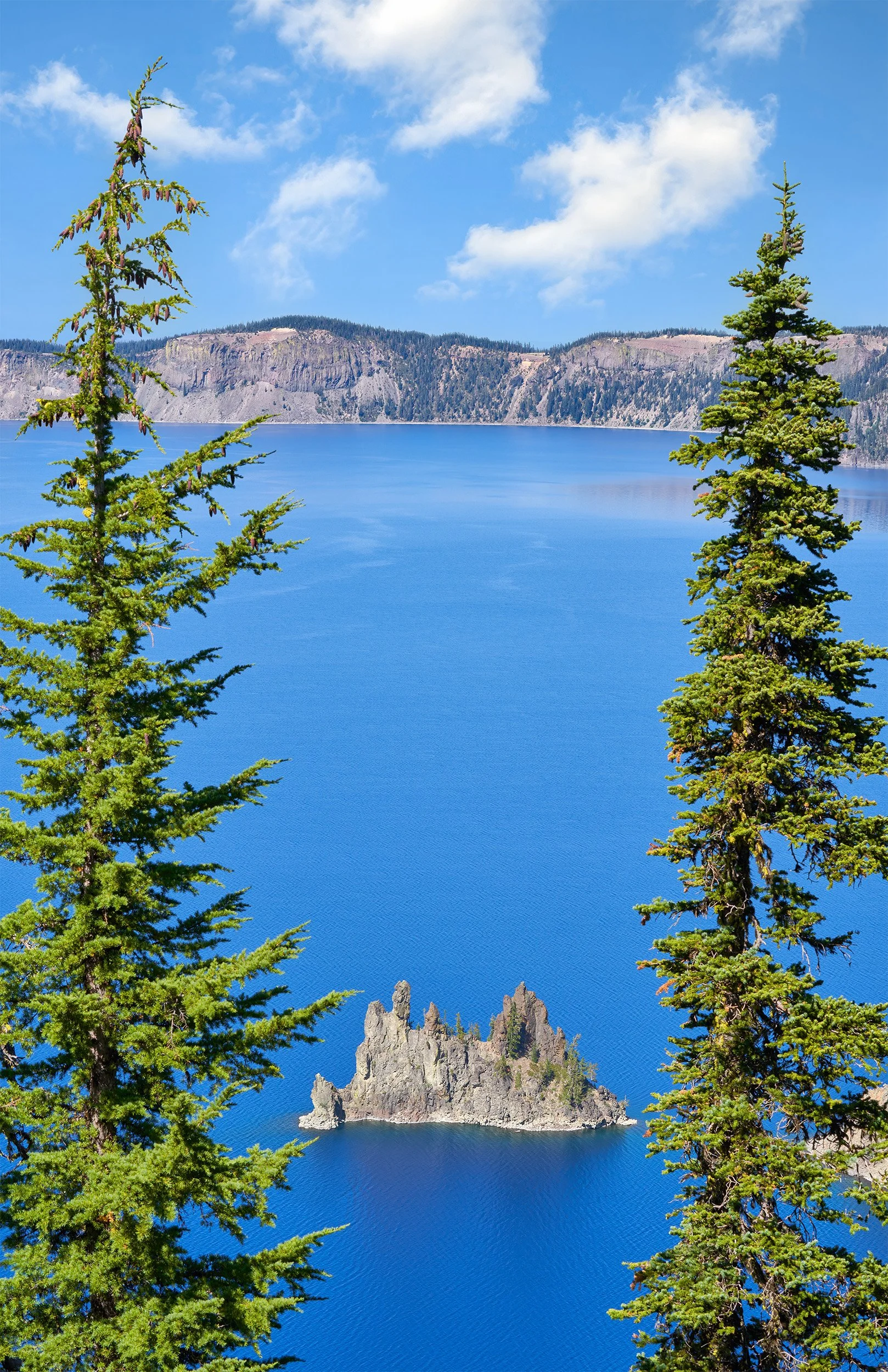 Phantom Ship at Crater Lake National Park with two tall trees framing the sides of the photo.