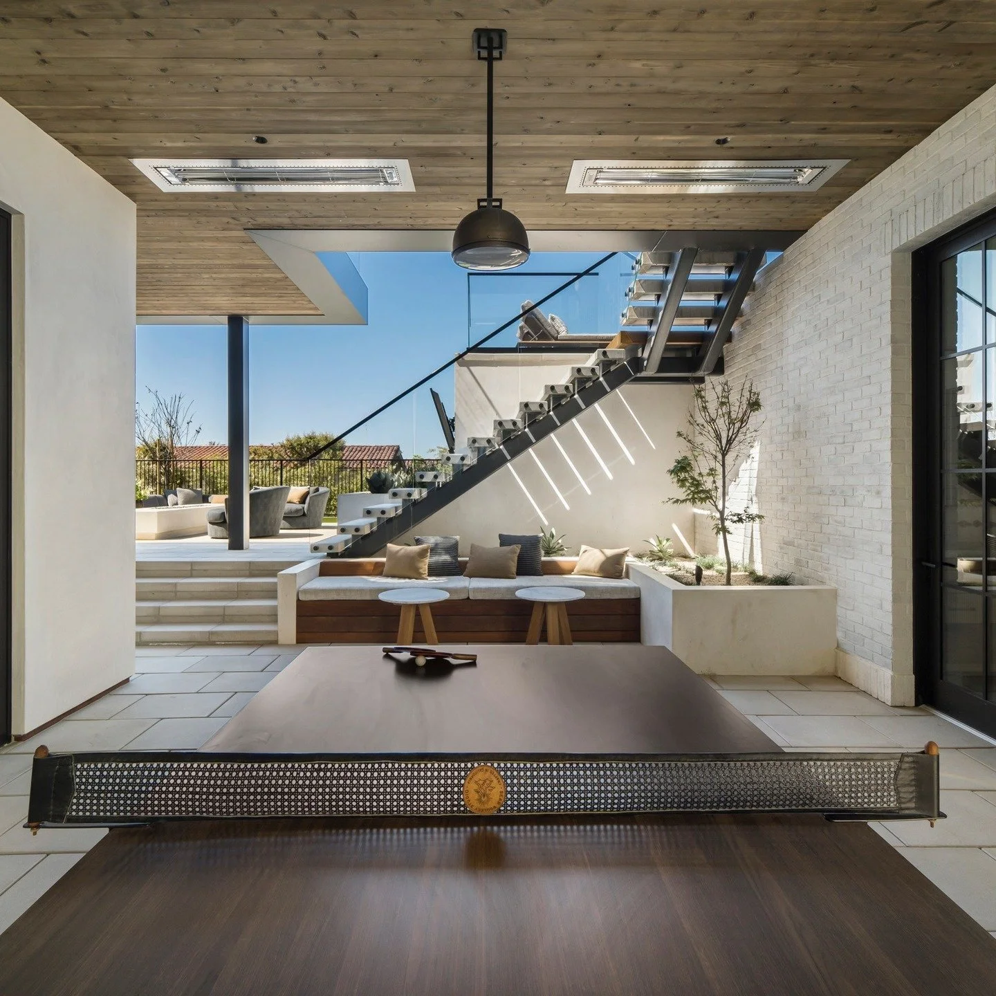Who needs Balboa when you have the fun zone at home? Overhead heaters, bench seating, and of course, ping pong make this courtyard a backdrop to your family gatherings. 

Architecture: @brandonarchitects 
Builder: @pattersoncustomhomes 
Interiors: @m