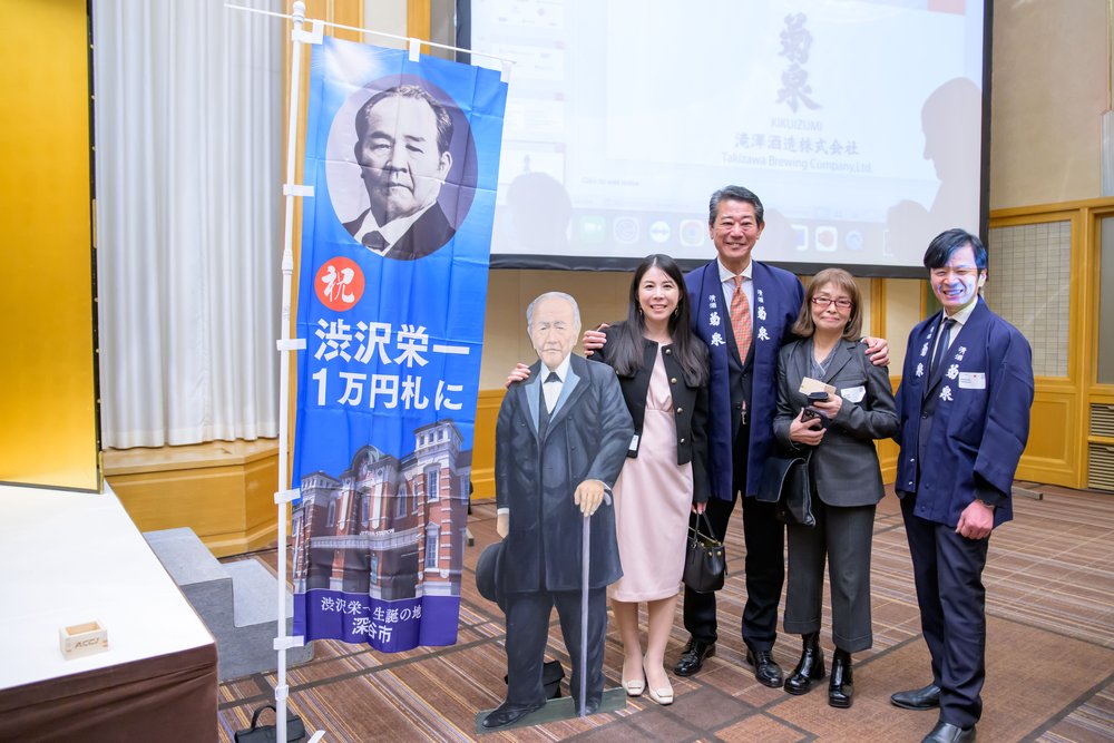  Guests pose with the life-size cutout of the industrialist Shibusawa Eiichi, the new face of the 10,000 yen bill. 