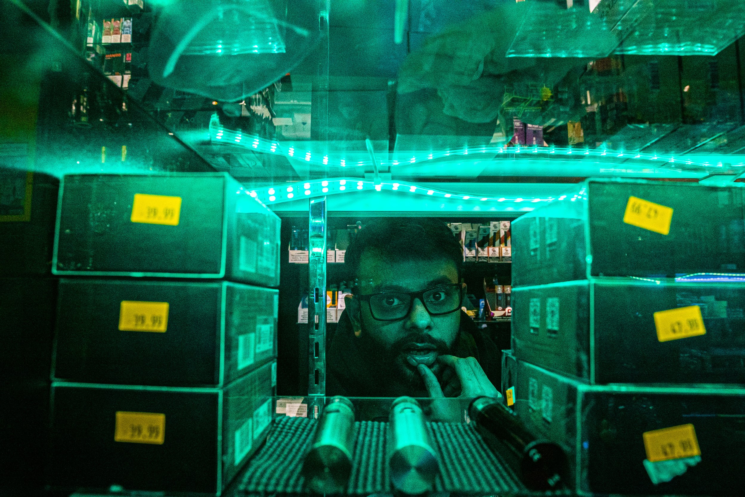  Up in Smoke cashier, Omer Noor cleans the shelves before the Thursday night rush on Thursday, February 20th, 2020. Omer has been an employee of Up in Smoke for about three years. (Tate Hilyard/The Daily Iowan) 