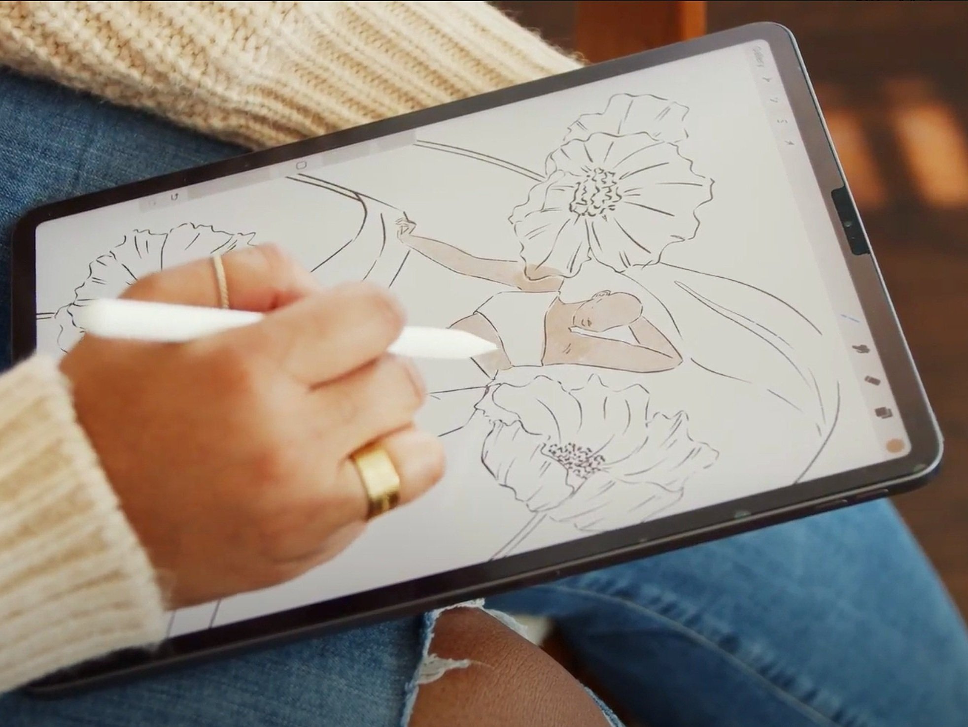 Person drawing on a tablet using a stylus, creating an illustration of a person surrounded by large flowers.