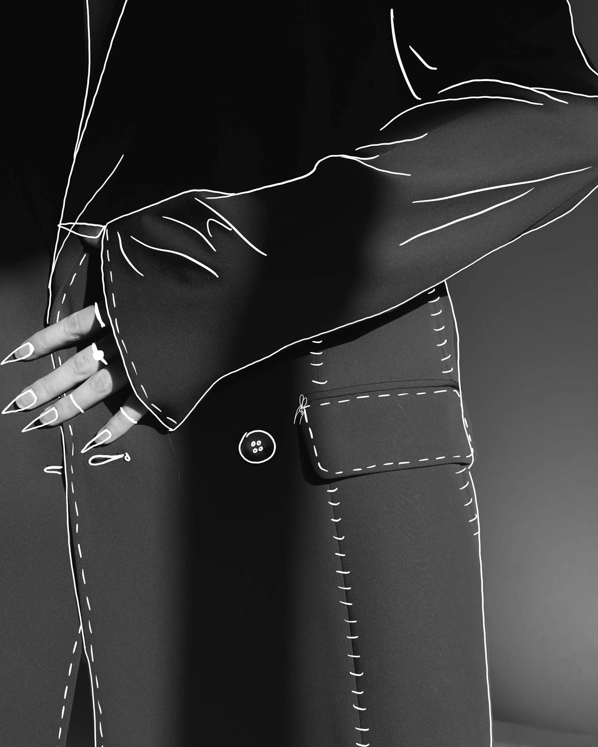 Close-up of a person's arm and hand, with digital line art overlay highlighting the coat's sleeve, pocket, and buttons.