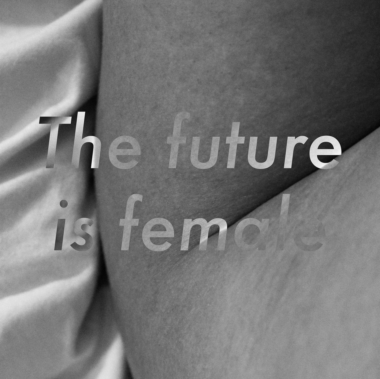 Black and white photo of a person's body with a fabric draped nearby. Overlaid text reads 'The future is female'.
