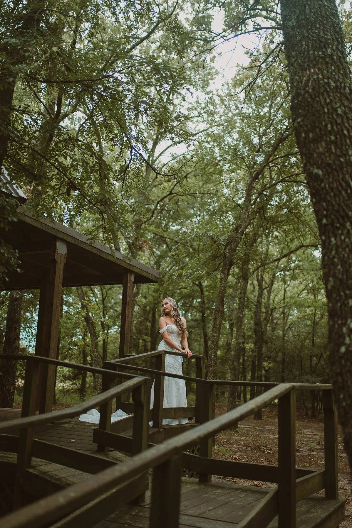 Bride standing in trees at forest wedding venue in North Texas.