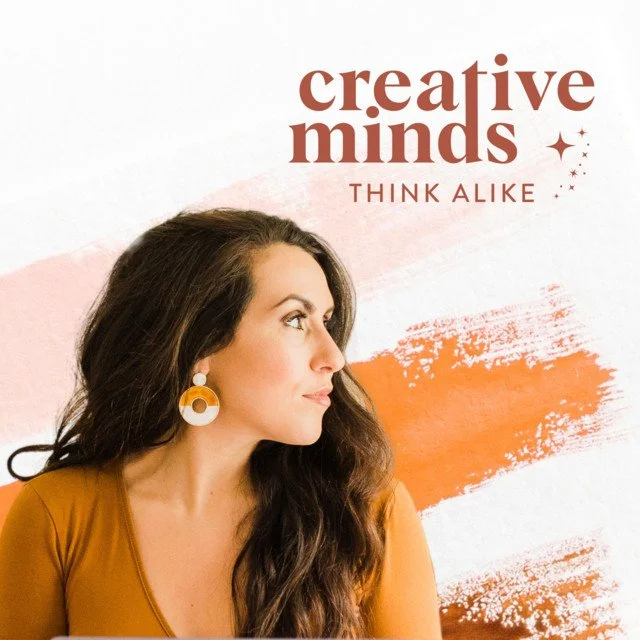 A woman with long brown hair wearing a mustard yellow top and large orange earrings, looking to the left, with a background featuring an orange brush stroke and pink abstract design, and text that reads "creative minds" and "THINK ALIKE."