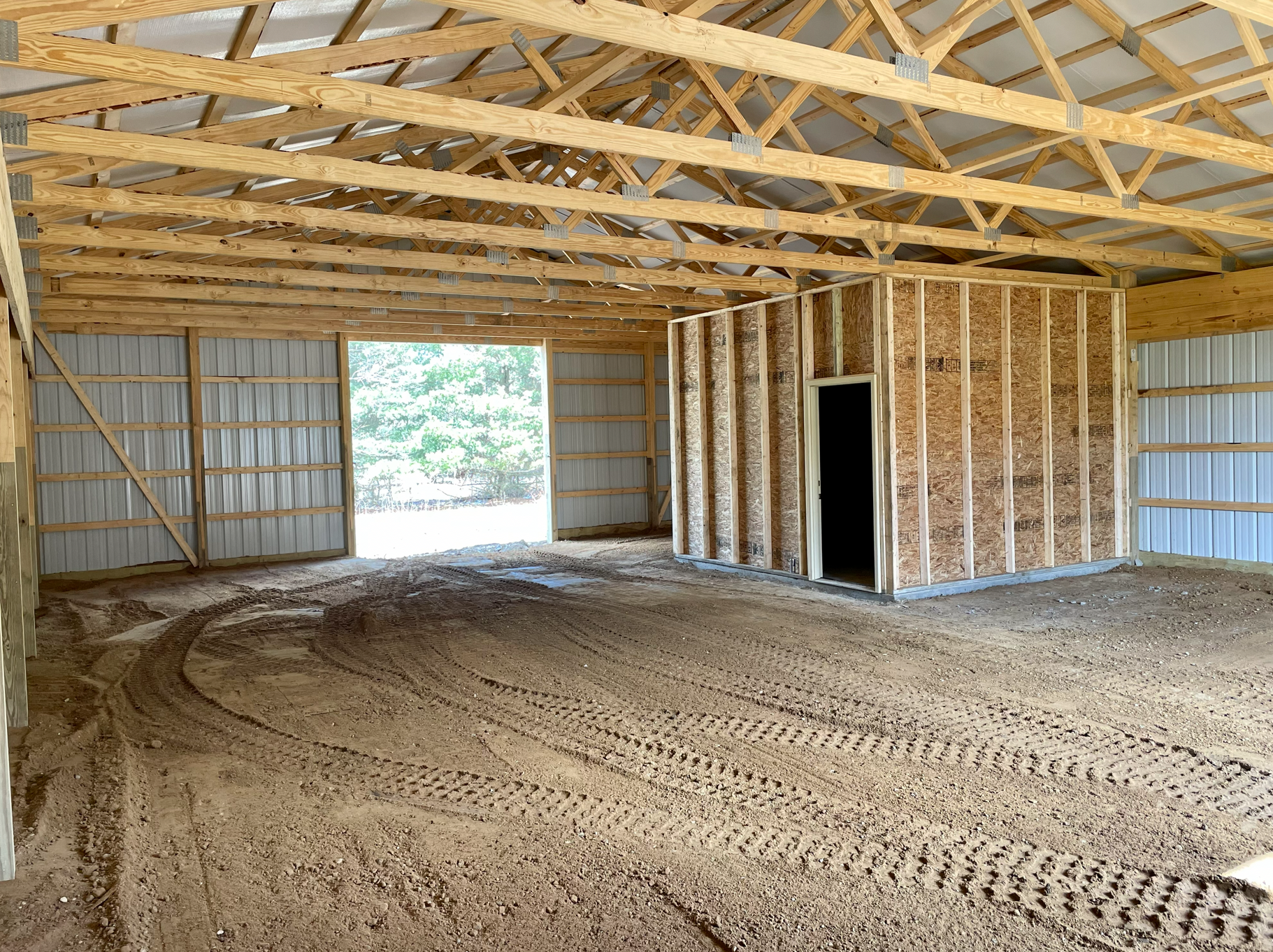 Interior of a pole barn with dirt floors and a storage space. 