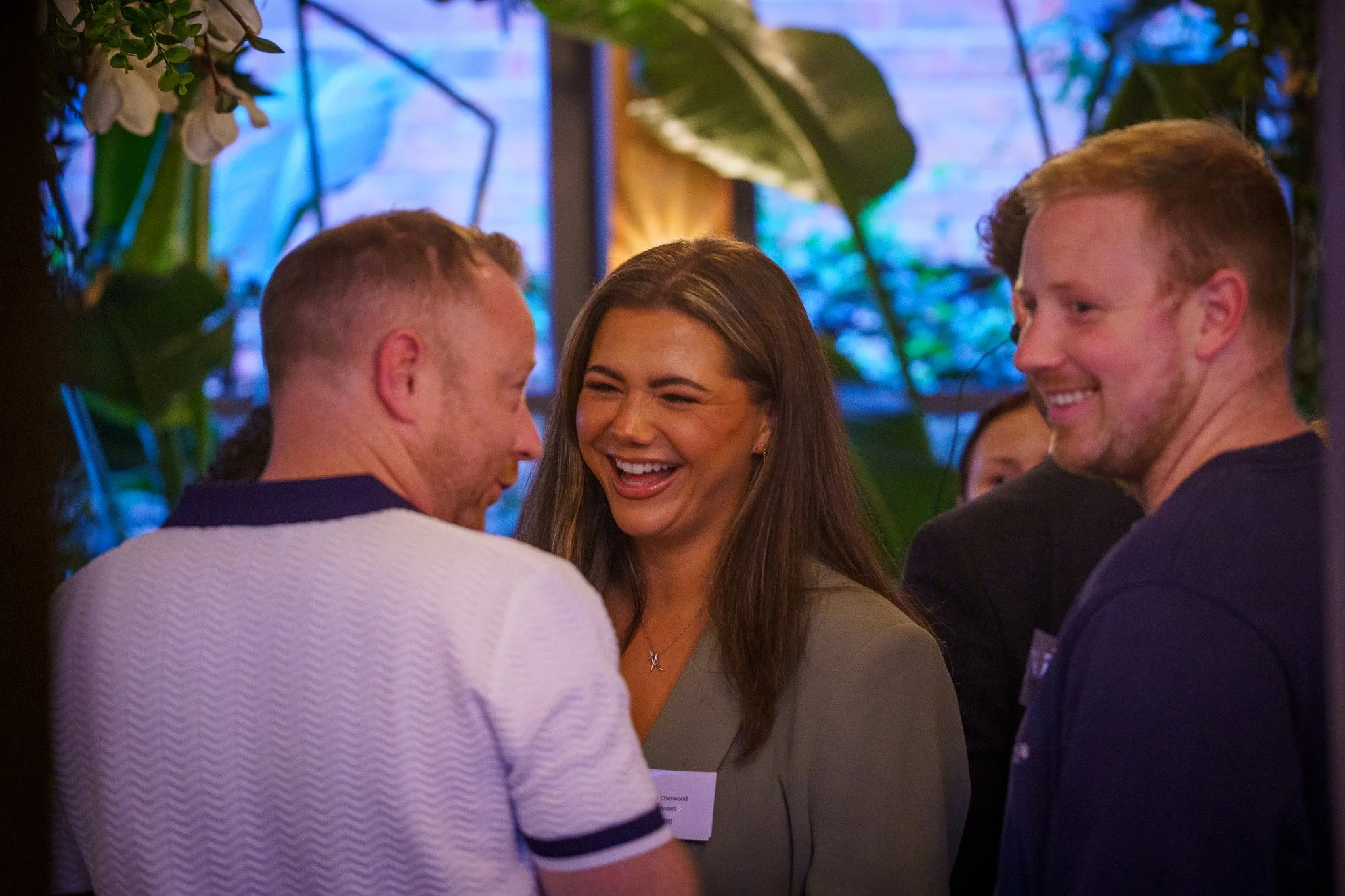 A group of smiling people engaged in conversation at an indoor networking event in Chester, cheshire 