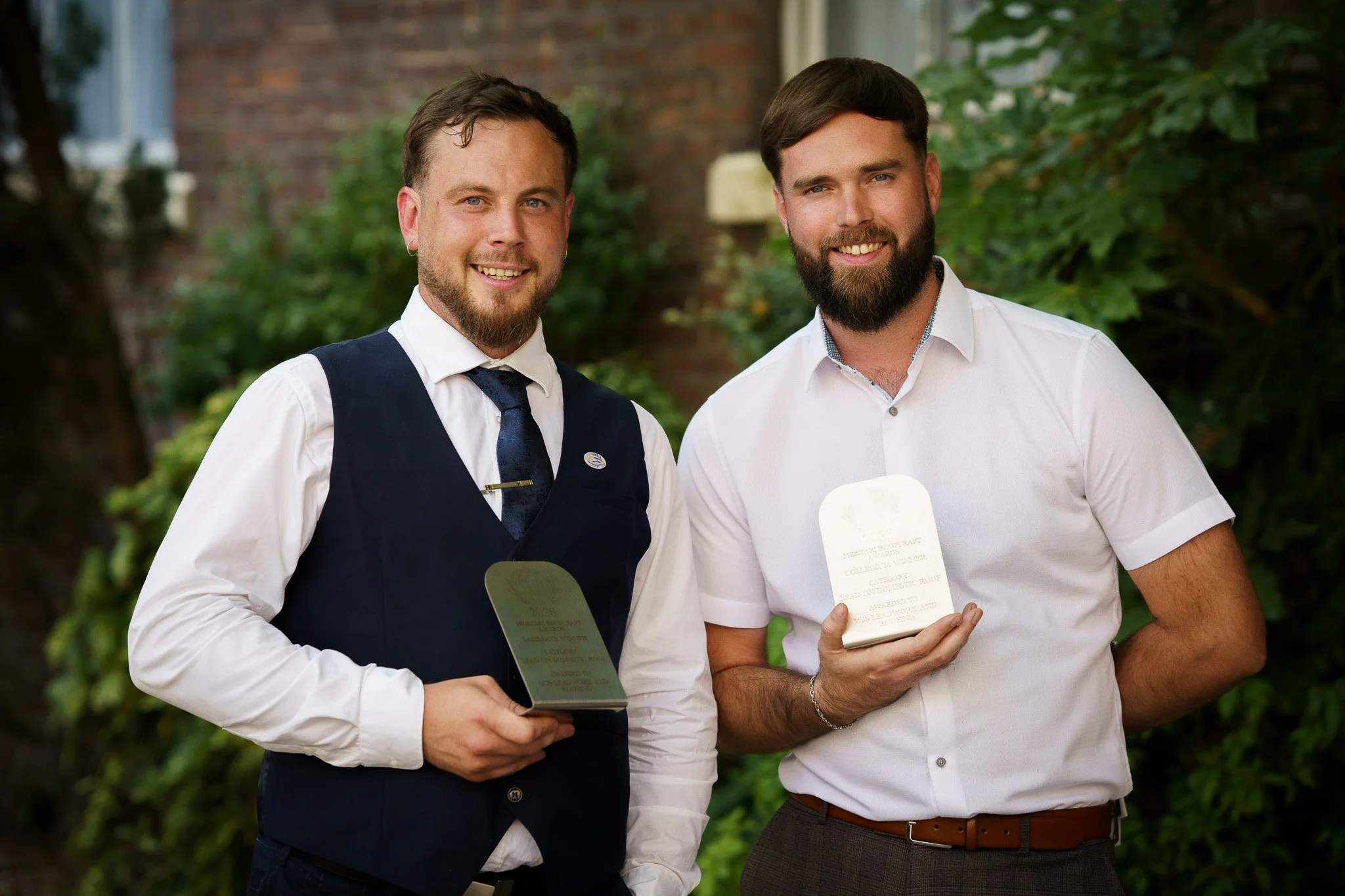 Environmental portrait of Two men with beards and holding awards at outdoor awards event in Chester, Cheshire