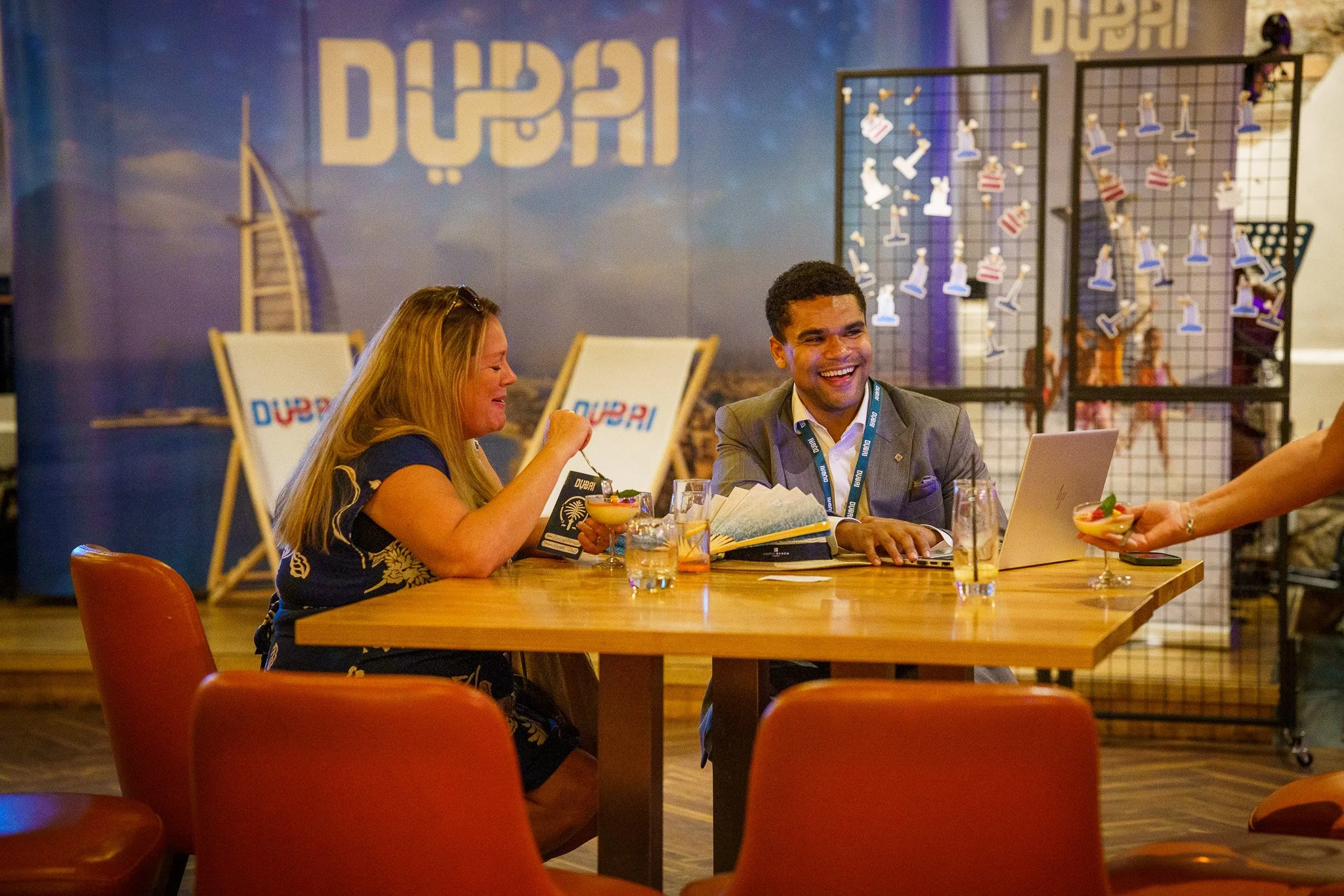 Two women and one man sitting at a wooden table in a Dubai-themed networking event in Chester, Cheshire