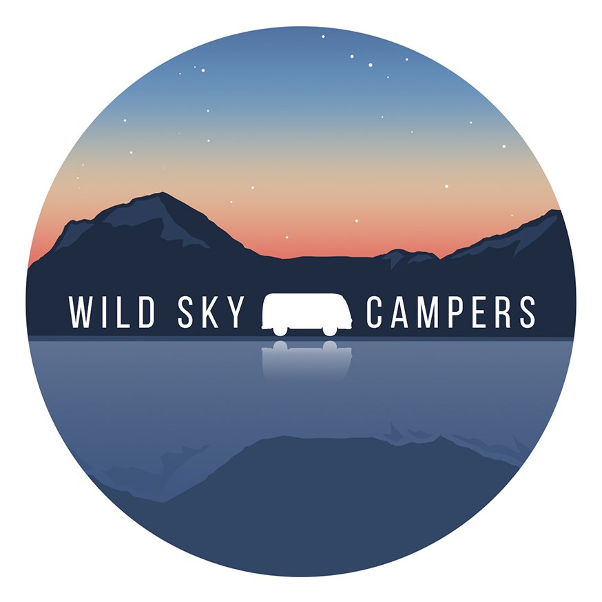 A circular logo for Wild Sky Campers featuring a mountain landscape at sunset with stars beginning to appear, a lake reflecting the mountains and sky, and a silhouette of a camper van in the center with the company name.