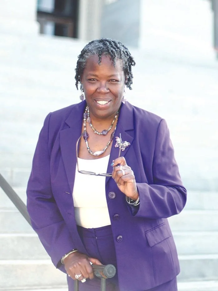 A woman in a purple pantsuit