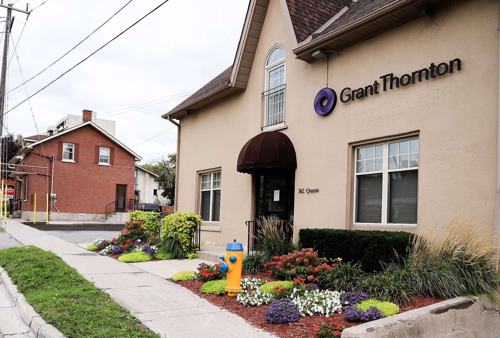 Exterior of Grant Thornton office building with landscaping, sidewalk, and a yellow fire hydrant.