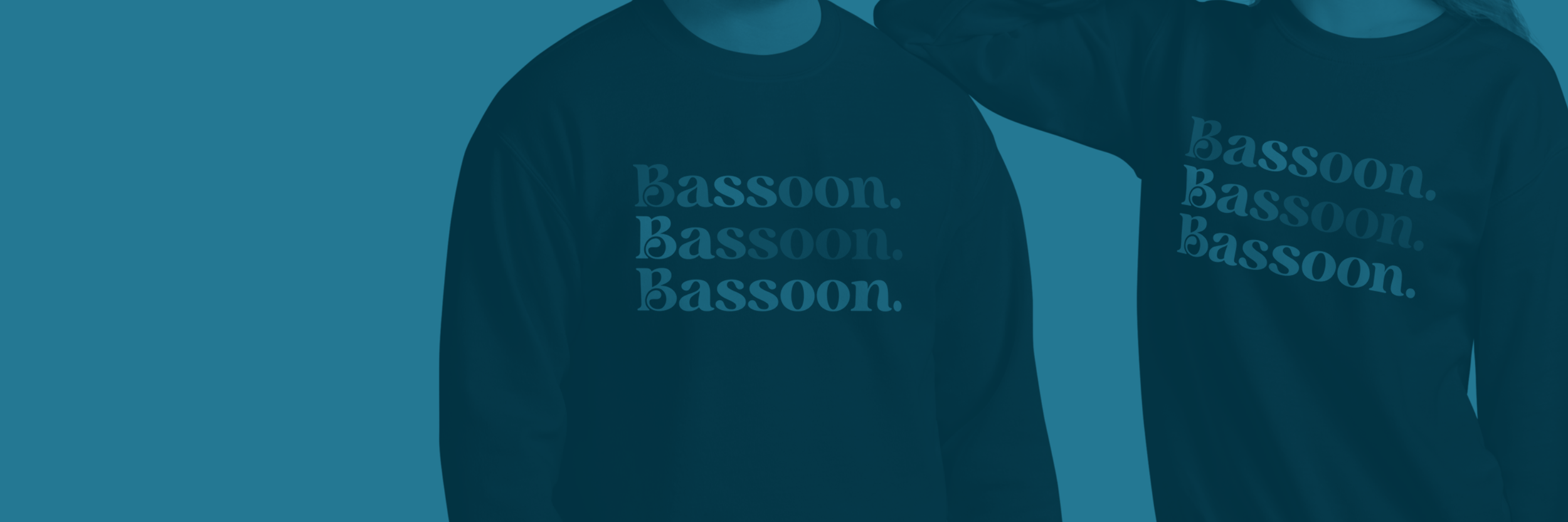 Two people wearing matching dark blue sweatshirts with the words 'Bassoon.' printed repeatedly on the front, standing side by side.