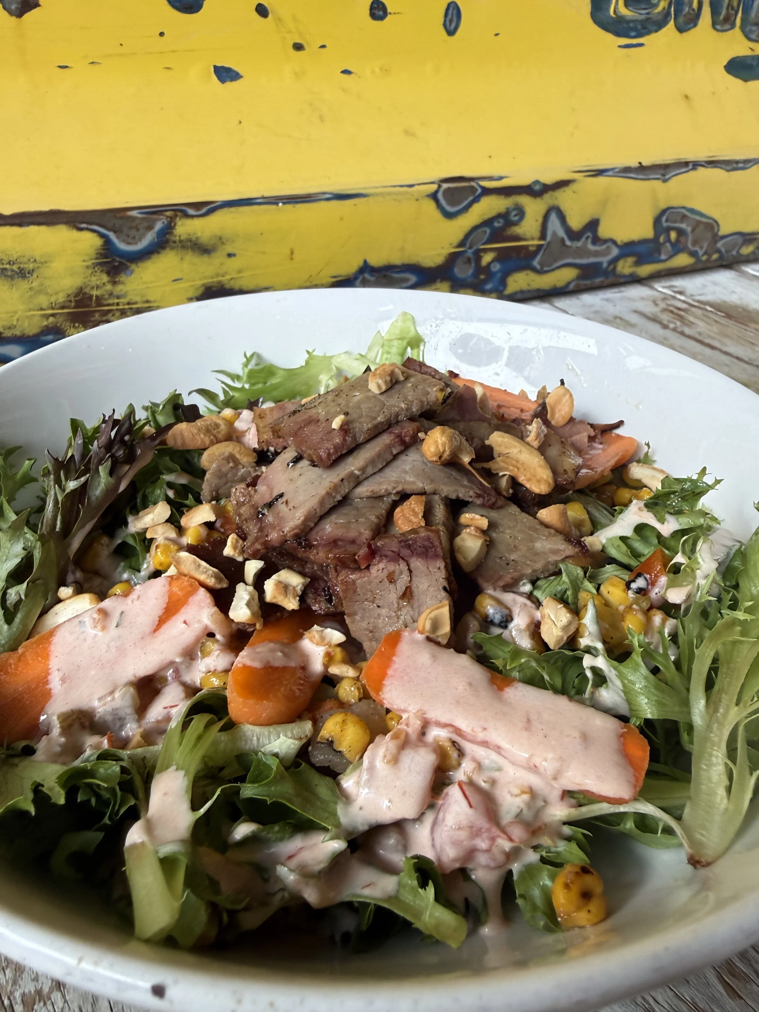 Brisket street corn salad - mixed greens, corn and black bean salsa, baby carrots, salsa ranch, brisket, crumbled toasted nuts