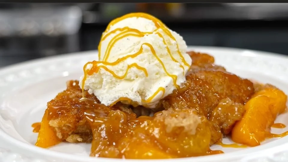 Peach Cobbler served with salted caramel ice cream and a caramel drizzle