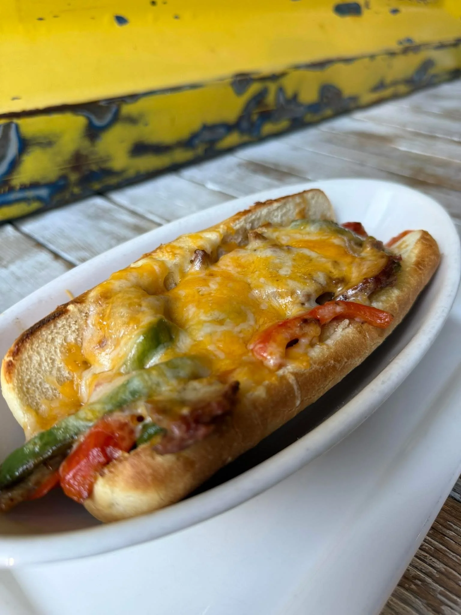 Feature Sammy: Slow roasted brisket and peppers topped with melted cheddar jack cheese on a toasted hoagie