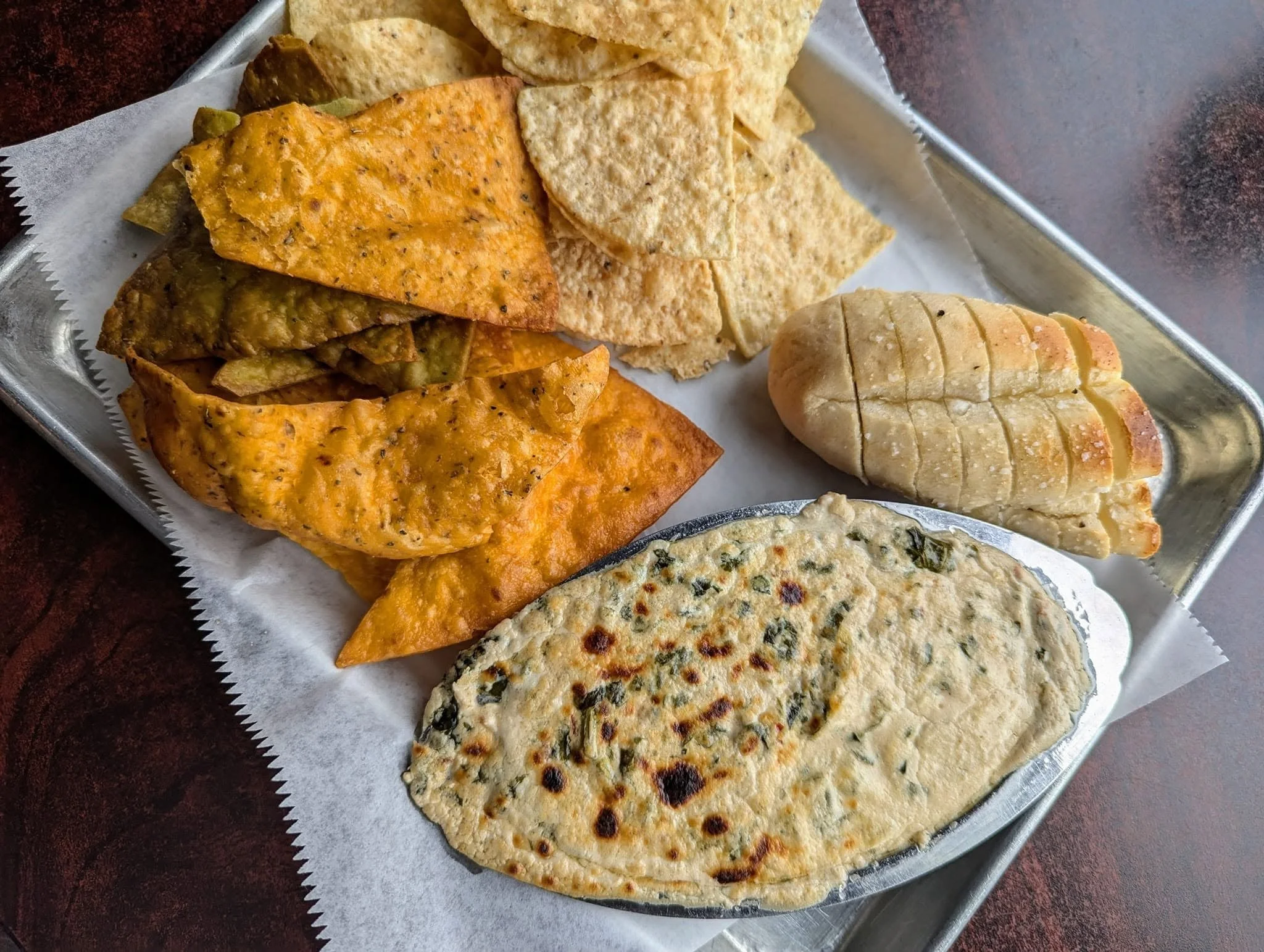 Our famous Goat Cheese Artichoke Dip served with our House chips, corn chips, and warm bread