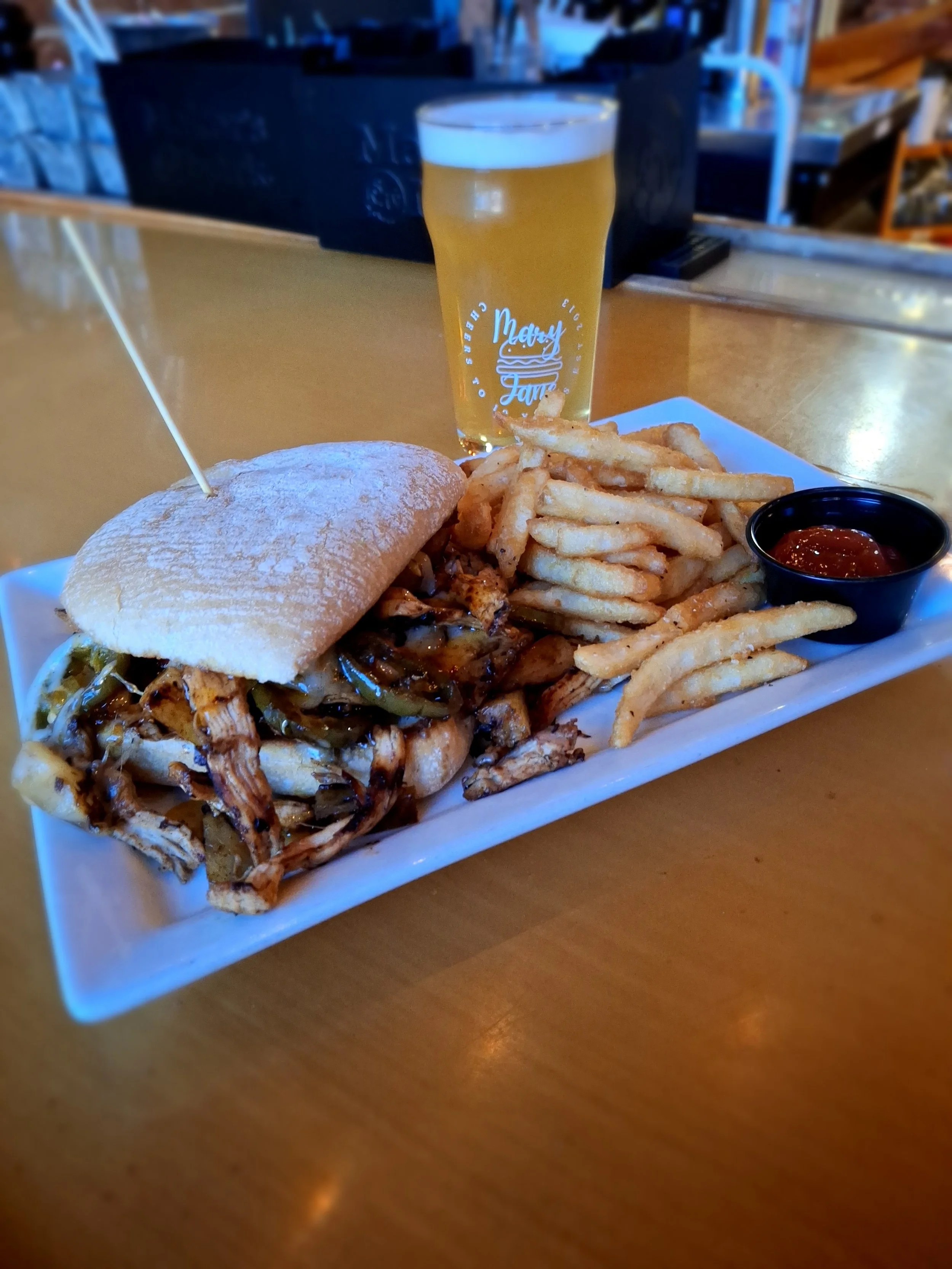 Feature Sammy: Smoked chicken piled high with melty pepper jack, fire-grilled jalapeños, sweet grilled pineapple, and a bold hot honey drizzle — all tucked into a fresh ciabatta bun.