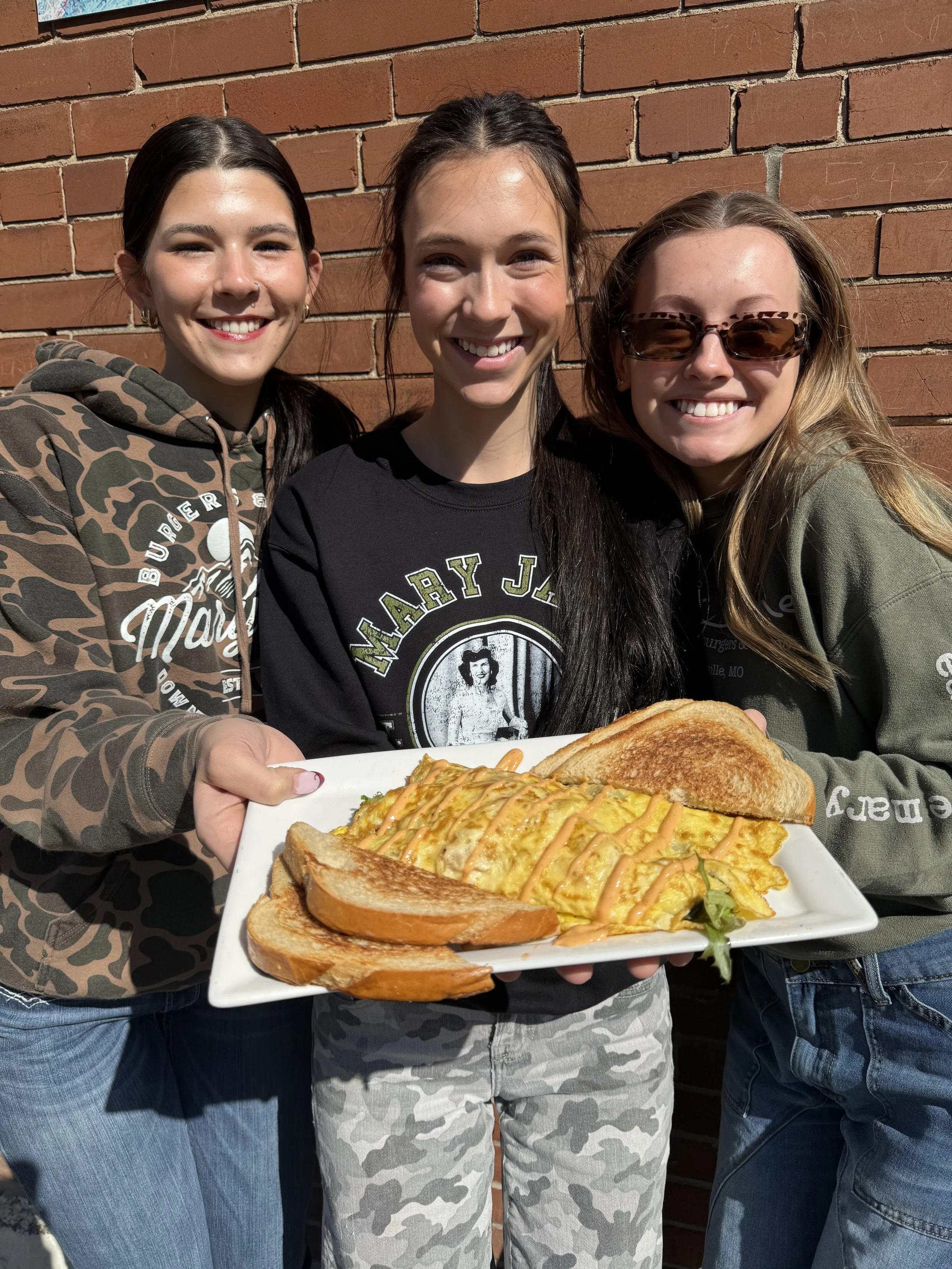 Brunch Omelette: 3 egg omelette filled with ham, turkey, mixed greens and diced tomato, topped with sriracha mayo drizzle.