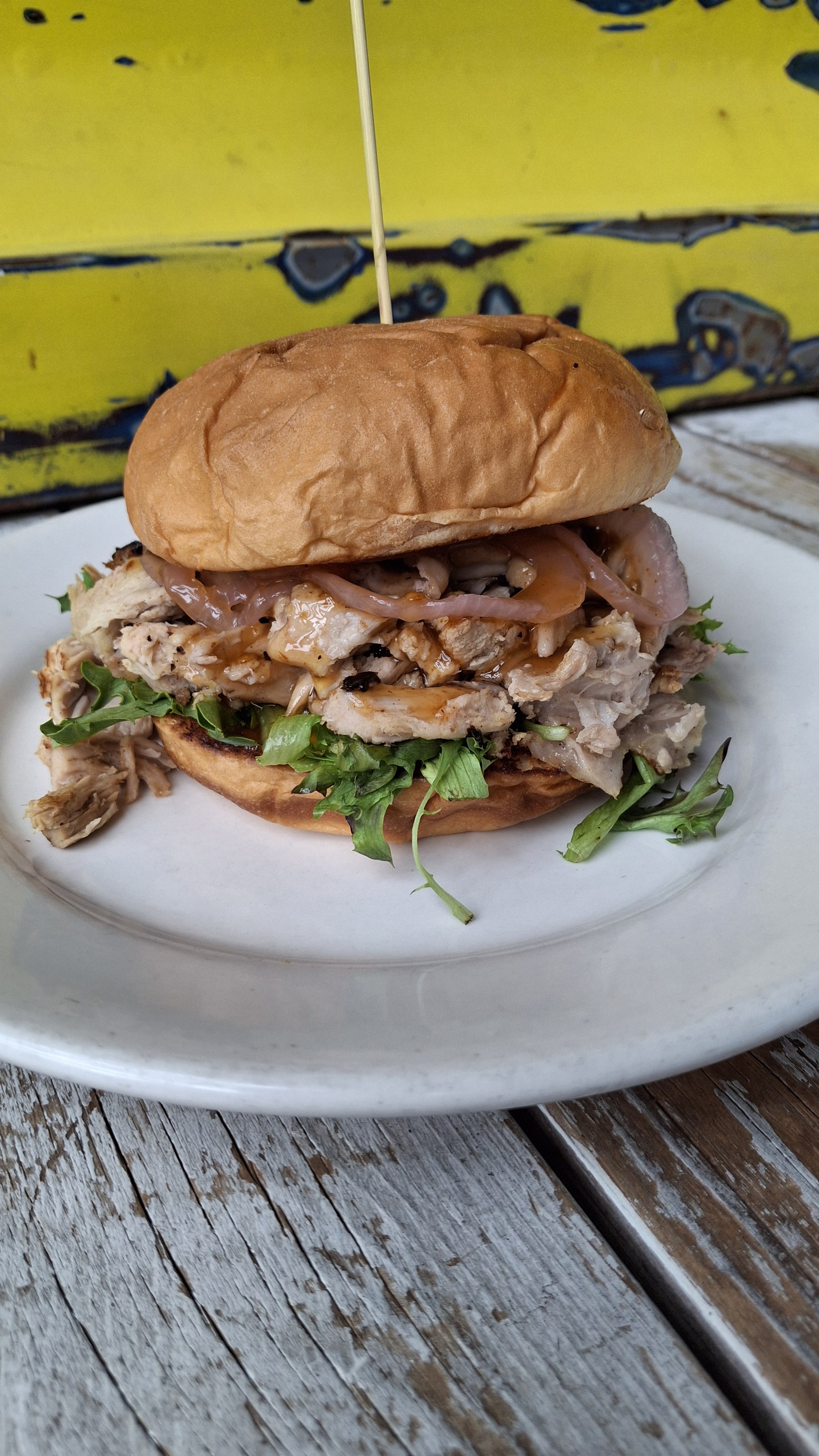 Feature Sammie -
Roasted Pulled Pork Sammie: slow-roasted, tender pulled pork piled high on a toasted bun, topped with crisp mixed greens, tangy pickled red onions, and finished with a bold drizzle of spicy hot honey. It’s sweet, it’s savory, it’s g