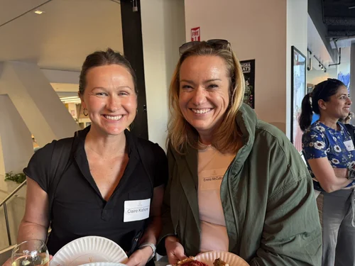 Two attendees smiling together at the mixer