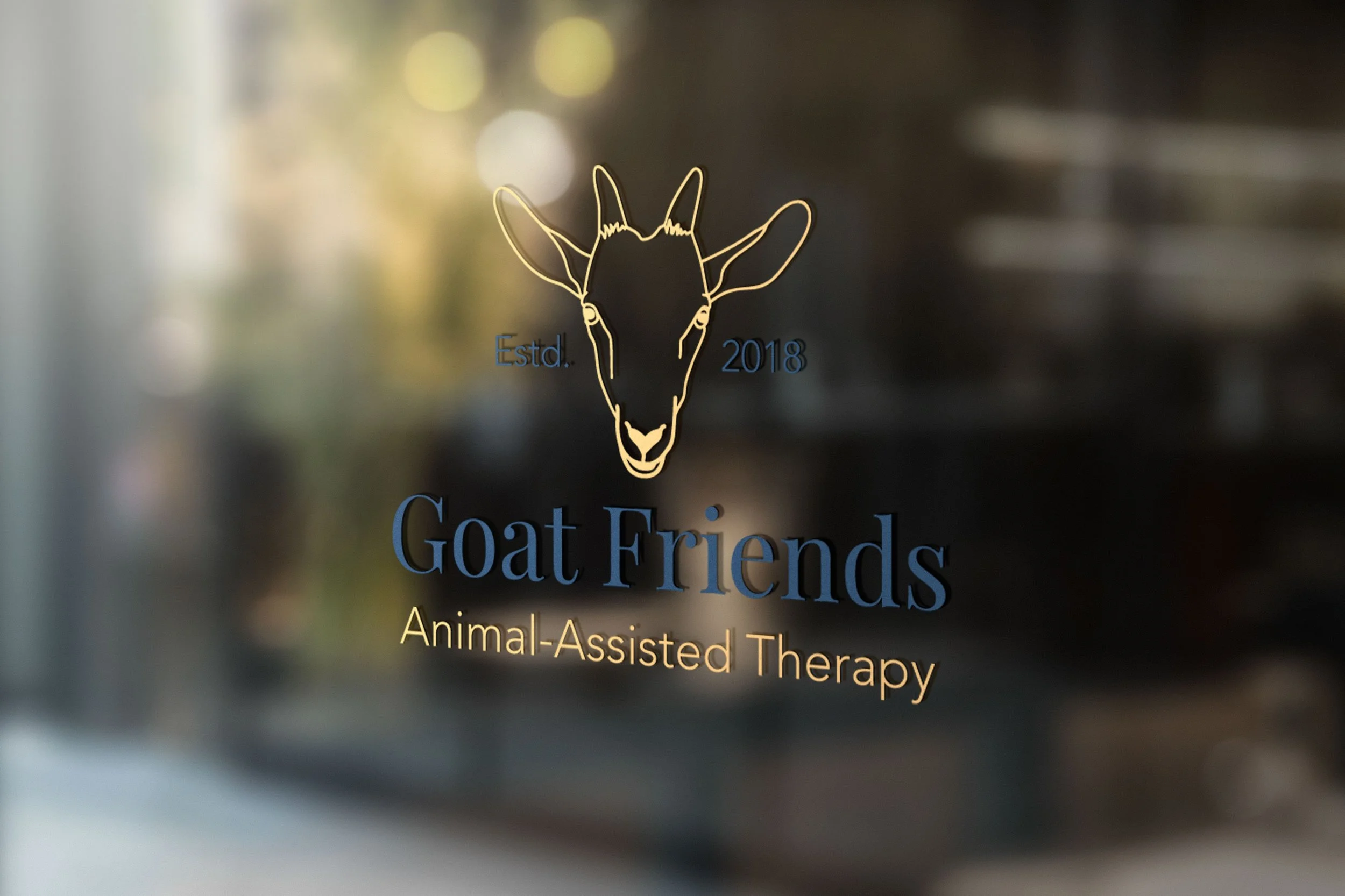 Yellow and  blue logo is mocked up on a glass window as a vinyl decal. Window has blurry reflection of street.