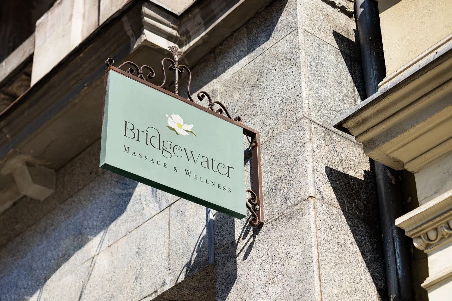 Bridgewater Massage & Wellness' full color logo is shown on a sign on the side of a concrete building