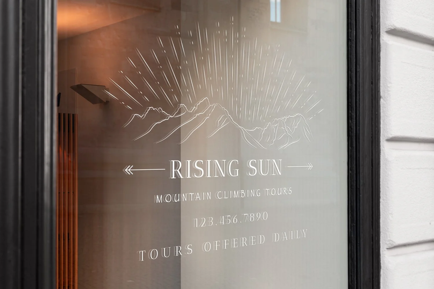 All white logo is mocked up as a vinyl window decal, shown at an angle from the left, and placed above business phone number and "TOURS OFFERED DAILY"