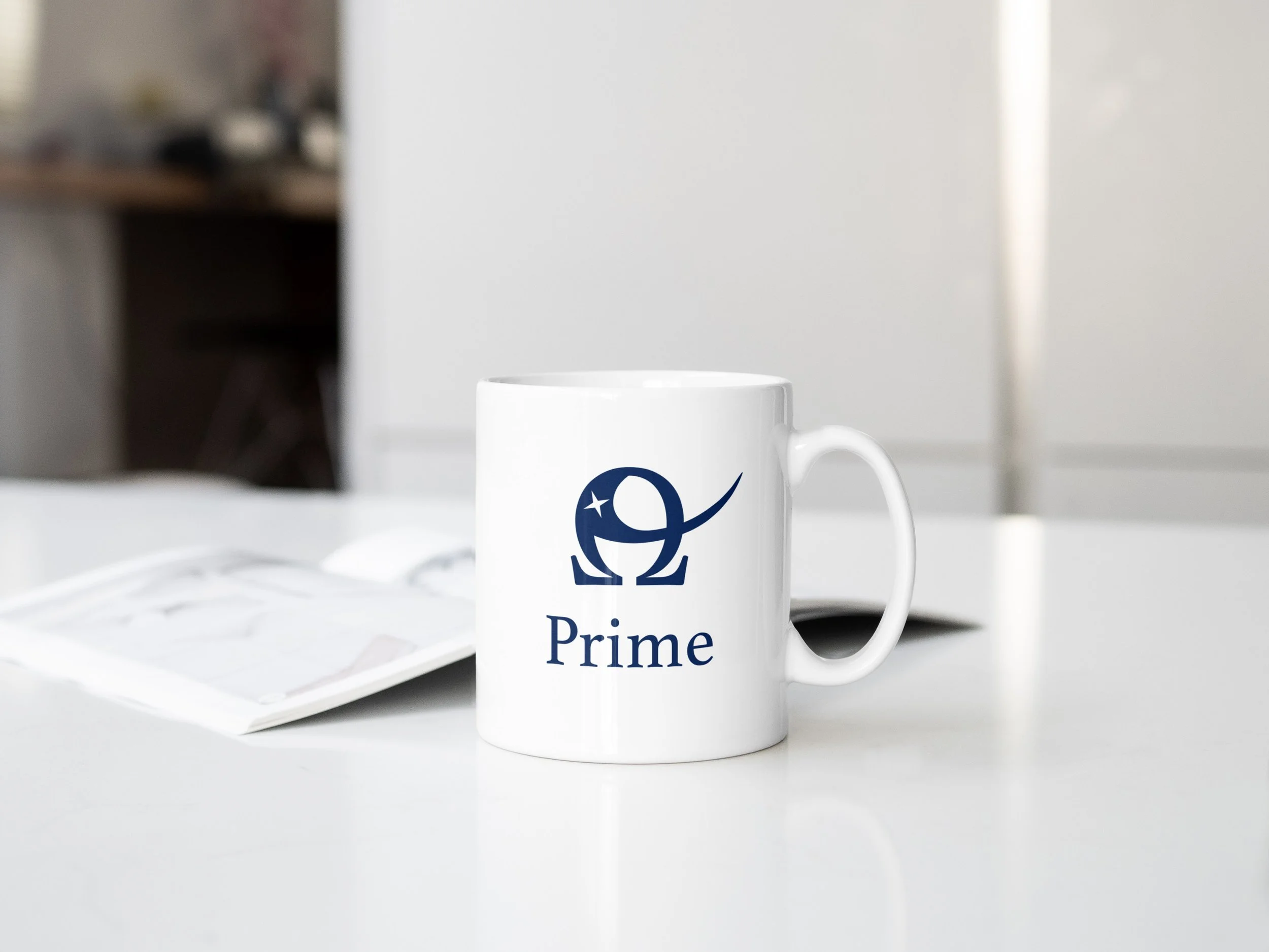 All navy logo is mocked up on white coffee mug, on a white table with an opened book lying behind it, out of focus