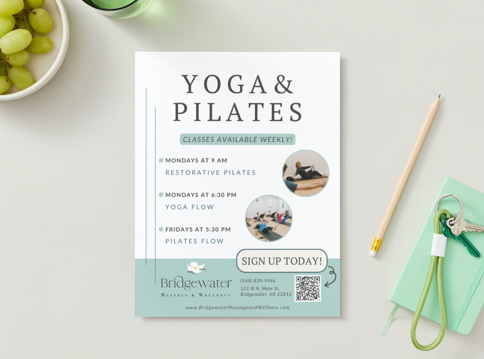 A "YOGA & PILATES" flyer showcases the class names and schedule, class photos, business logo, & signup info. Flyer lies on gray counter with pencil and keys to right.