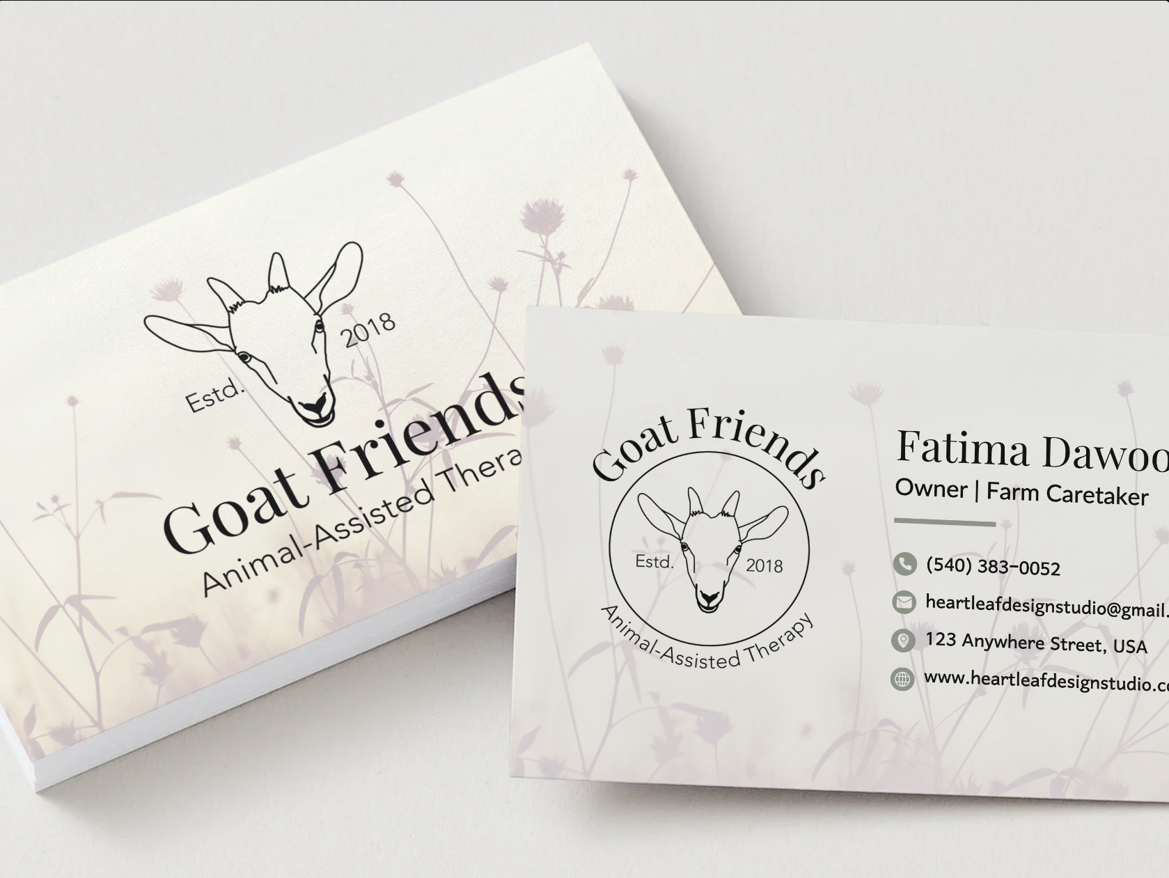 On the left: a stack of business cards featuring "Goat Friends Animal-Assisted Therapy" with a goat head graphic (business logo) and a faded floral background. On the right: back of the business card is shown, featuring alternate logo and owner info.